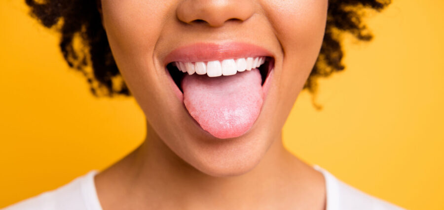 cropped closeup of Black woman sticking her tongue out against a yellow background